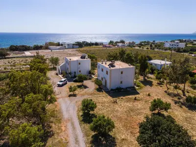 an aerial view of two white buildings next to the ocean at BABIS & POPI APARTMENTS in Frangokastello