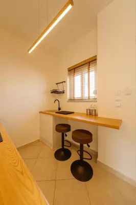 a kitchen with a sink and two bar stools at El Chacha Studio in Galatás
