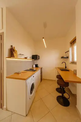 a kitchen with a washing machine and a desk at El Chacha Studio in Galatás