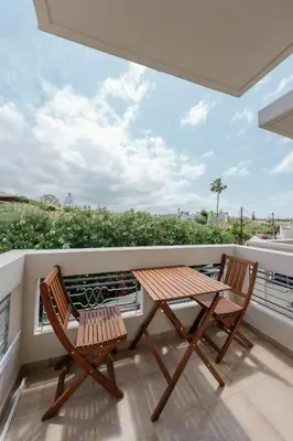 two chairs and a table on a balcony with a view at El Chacha Studio in Galatás