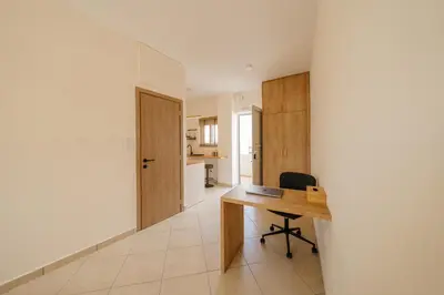 an empty room with a desk and a kitchen at El Chacha Studio in Galatás