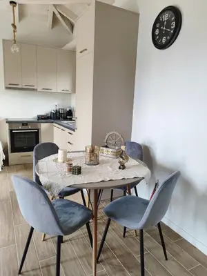 a dining room table with chairs and a clock on the wall at Coastal Haven Your Oasis by the Sea in Análipsis