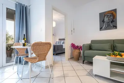 a living room with a couch and a table and chairs at Soul Living City Apartement in Chania Town