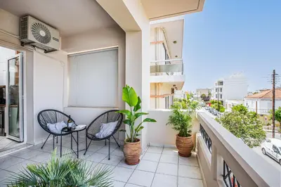 a balcony with two chairs and potted plants at Soul Living City Apartement in Chania Town