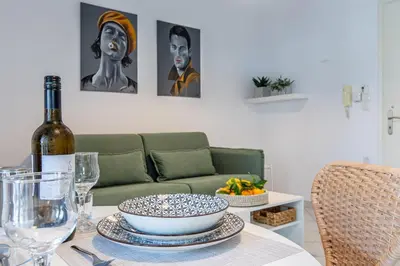 a table with a bottle of wine on a table with a couch at Soul Living City Apartement in Chania Town