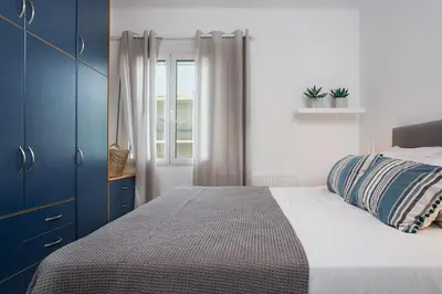a bedroom with a bed with blue cabinets and a window at Soul Living City Apartement in Chania Town