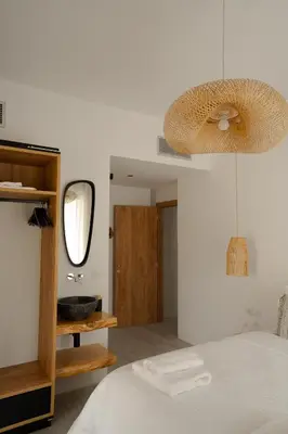 a bedroom with a bed and a sink and a mirror at Athos Guesthouse in Stalos