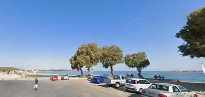 a parking lot with cars parked next to the water at Sun Beach Apartment in Chania 3 in Chania Town