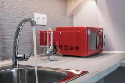 a red toaster sitting on a kitchen counter next to a sink at Casa Αrezio in Chania Town