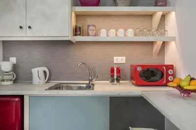 a kitchen with a sink and a red microwave at Casa Αrezio in Chania Town