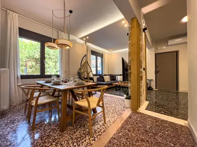 a dining room and living room with a table and chairs at Apẽron Suite - Downtown Chania in Chania Town