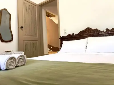 a bedroom with a large bed with a wooden headboard at Kyparissos Apartment II in Kissamos