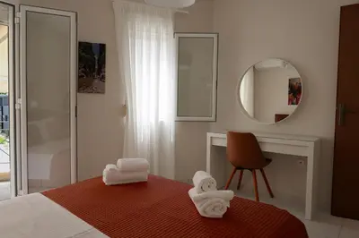 a bedroom with a bed and a mirror and a desk at Sunbeam Retreat in Chania Town