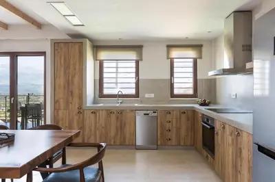 a kitchen with wooden cabinets and a table with chairs at Upper View Villa, with private pool in Chania Town