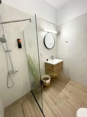 a bathroom with a shower and a sink and a mirror at Thali central apartment with parking in Chania Town