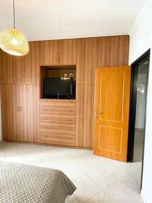 a bedroom with a tv and a wooden wall at Thali central apartment with parking in Chania Town