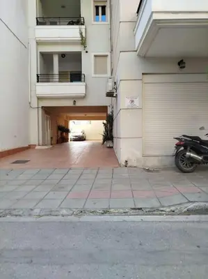 a motorcycle parked next to a building with a garage at Thali central apartment with parking in Chania Town
