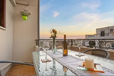 a table with glasses and a bottle of wine on a balcony at Artistic Apartment in Chania in Chania Town