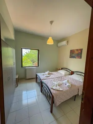 a bedroom with two beds and a window at Villa Marianna Lygides in Ayiá