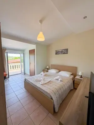 a bedroom with a large bed and a balcony at Villa Marianna Lygides in Ayiá