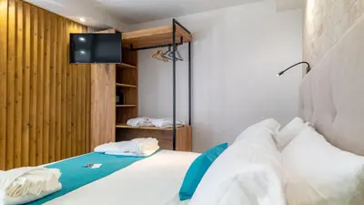 a bedroom with a bed with a tv on the wall at D PALM Premium Living - Kalathas, Chania in Chania Town
