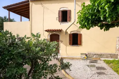 a house with two windows and a yard at liofito village house in Pemónia