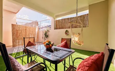 a room with a table and chairs and a hammock at Cretan Fun in Stalos