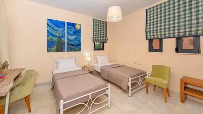 a room with two beds and a table and chairs at Lithos Serenity in Argoulidhés