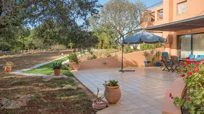 a patio with an umbrella next to a house at Lithos Serenity in Argoulidhés