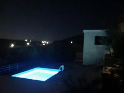 a swimming pool lit up in the dark at night at Pool Villa Kamara Crete - Chania in Chania Town