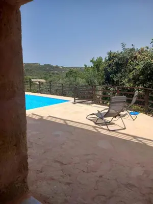 a chair sitting on a patio next to a pool at Pool Villa Kamara Crete - Chania in Chania Town
