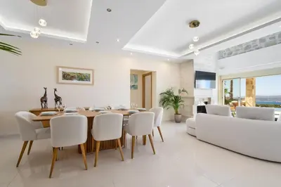 a dining room with a wooden table and white chairs at Villa Athena - Crete Pickleball Paradise in Vamos