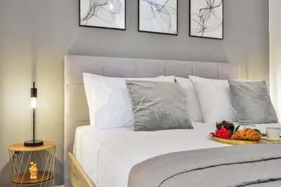 a bed with white sheets and a bowl of fruit on it at La Fleur in Chania Town