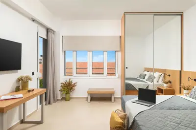 a bedroom with a bed and a desk with a laptop at Elia City Apartments in Chania Town