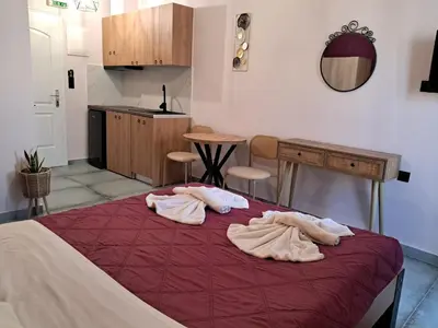 a bedroom with a bed with two robes on it at Poppy Beloni in Chania Town
