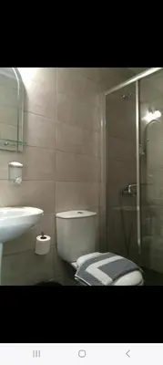 a bathroom with a shower and a toilet and a sink at Poppy Beloni in Chania Town