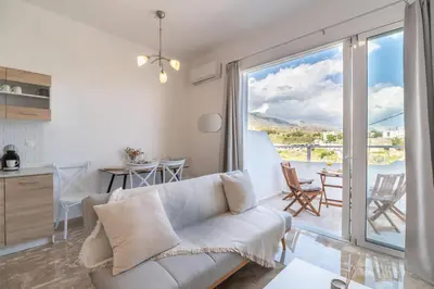 a living room with a couch and a table with chairs at Avra Sfakia Apartments in Khóra Sfakíon