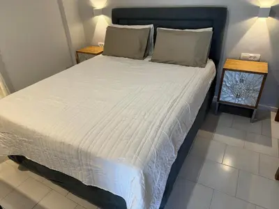 a bed with white sheets and pillows in a room at Sofia Rooms in Palaiochóra