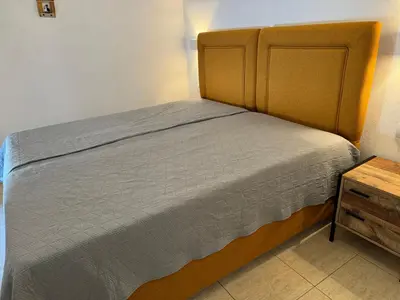 a small bed in a room with a wooden table at Sofia Rooms in Palaiochóra