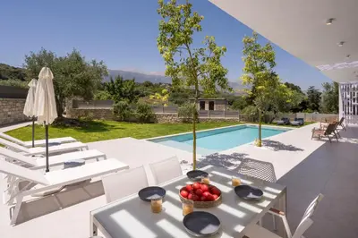 a patio with a table and chairs and a pool at VILLA PETRA PHILIPPOS heated pool optional in Khámbatha