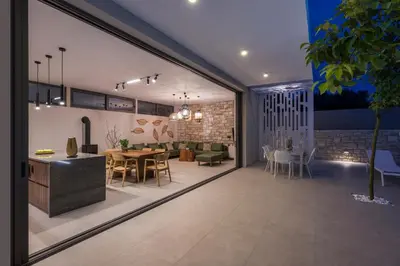a living room with a table and a dining room at VILLA PETRA PHILIPPOS heated pool optional in Khámbatha
