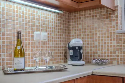a bottle of wine sitting on a counter with two wine glasses at City Apartment with heated rooftop Pool in Chania Town
