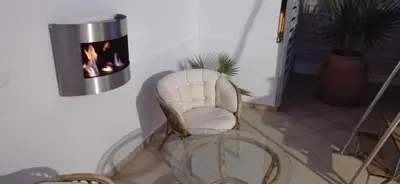 a white chair sitting in a room with a fireplace at City Apartment with heated rooftop Pool in Chania Town