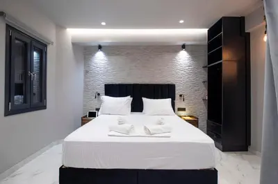 a bedroom with a large white bed with two towels at Melina's - Urban Luxury 2-Bath Apt with 2 Balconies - Heart of Chania in Chania Town