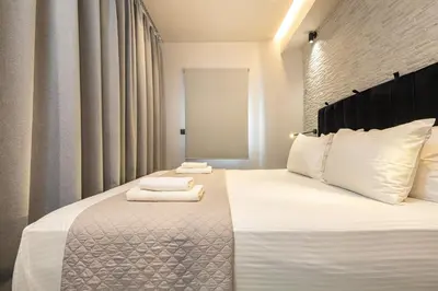 a bedroom with a bed with towels on it at Melina's - Urban Luxury 2-Bath Apt with 2 Balconies - Heart of Chania in Chania Town