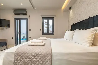 a bedroom with a large white bed with towels on it at Melina's - Urban Luxury 2-Bath Apt with 2 Balconies - Heart of Chania in Chania Town