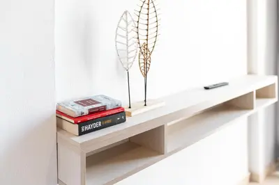 a shelf with books and a feather sculpture on it at Niman Beachside Apartments in Chania Town
