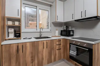 a kitchen with white cabinets and a sink at Niman Beachside Apartments in Chania Town