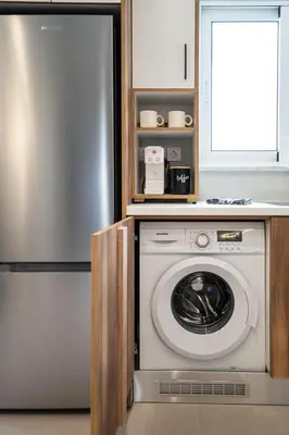 a kitchen with a washing machine and a refrigerator at Niman Beachside Apartments in Chania Town