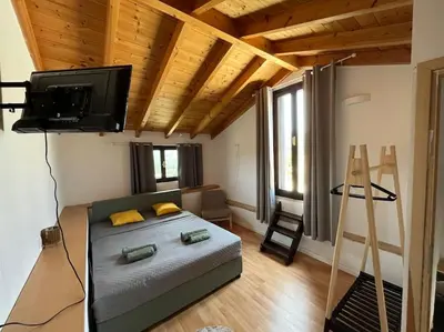 a bedroom with a bed and a flat screen tv at Vrysses Lodge Michael Stelianos in Vryses